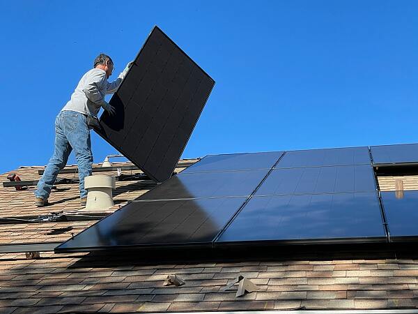 Mann installiert Solarpanelen
